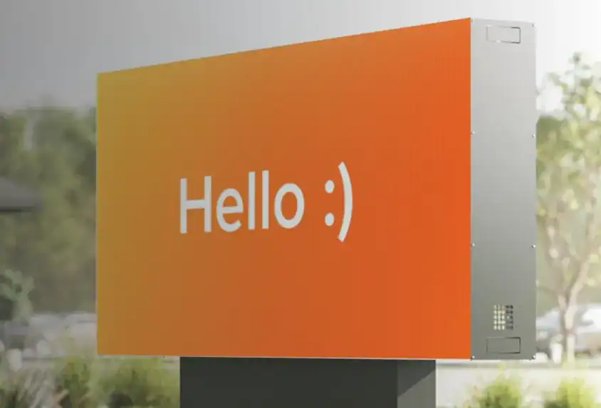 Freestanding LED sign with orange background and white “Hello :)” text, installed outdoors