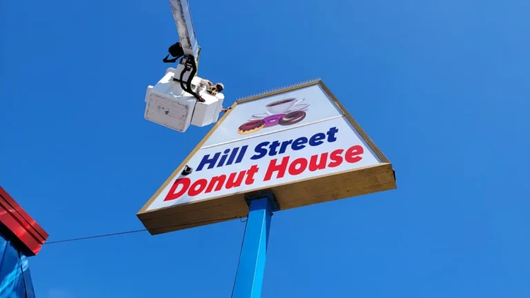 Pylon sign repair for Hill Street Donut House in Oceanside, CA, showing a bucket truck service.